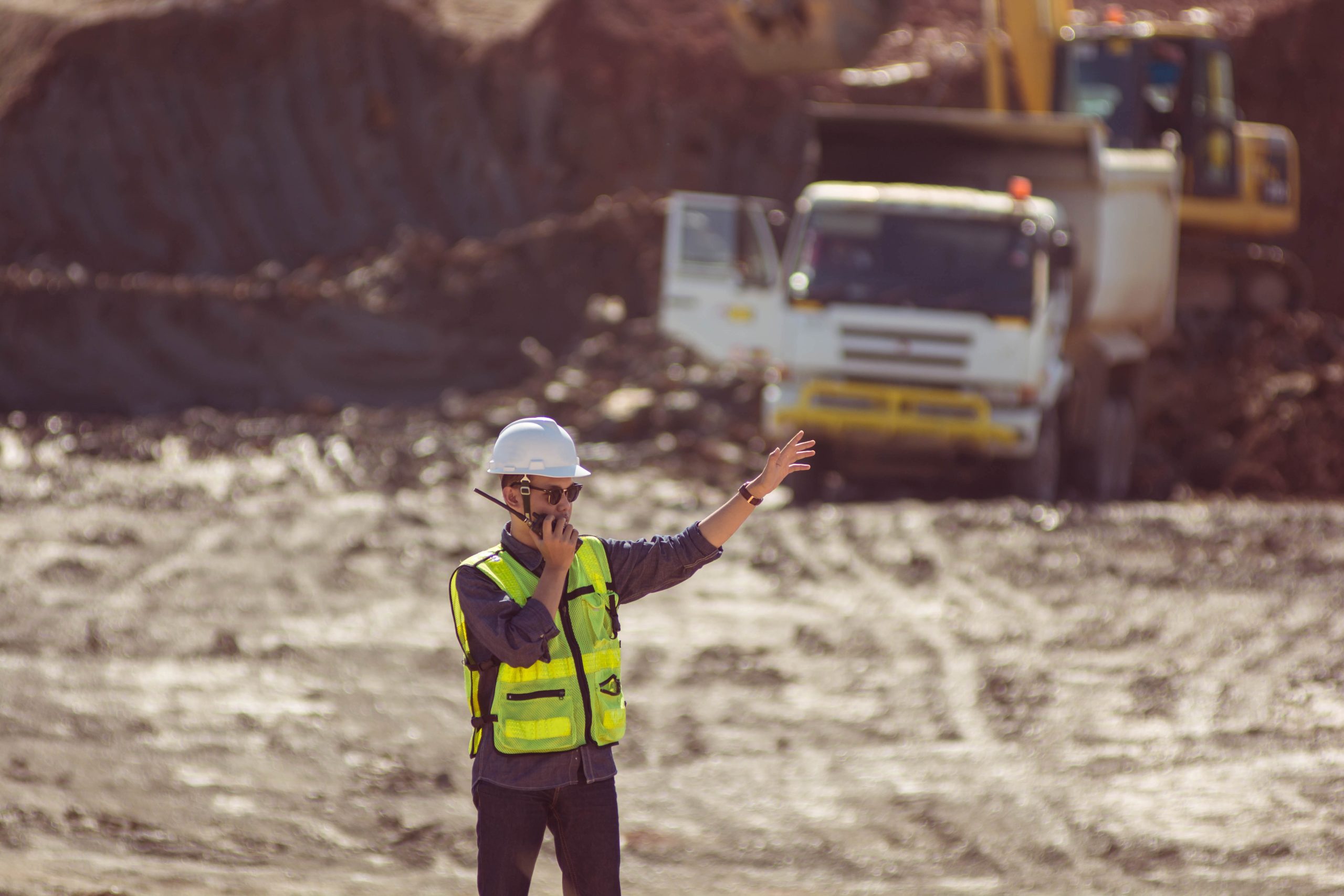 man using Motorola two-way radio on a construction site