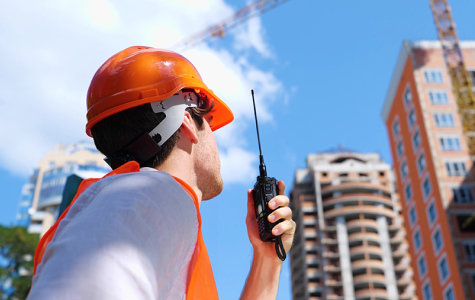 man with radio looking at building