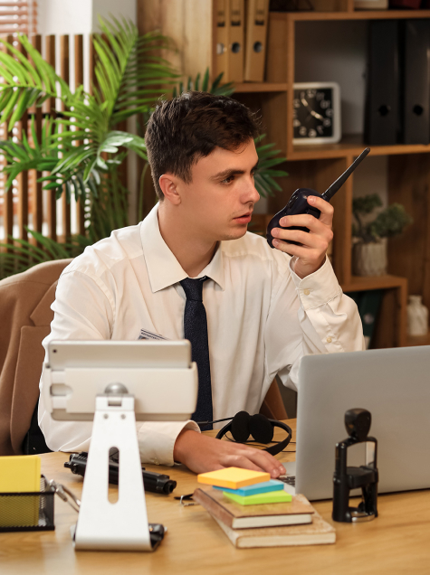 man at desk talking on radio