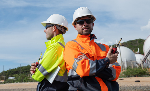 two men back to back holding radios